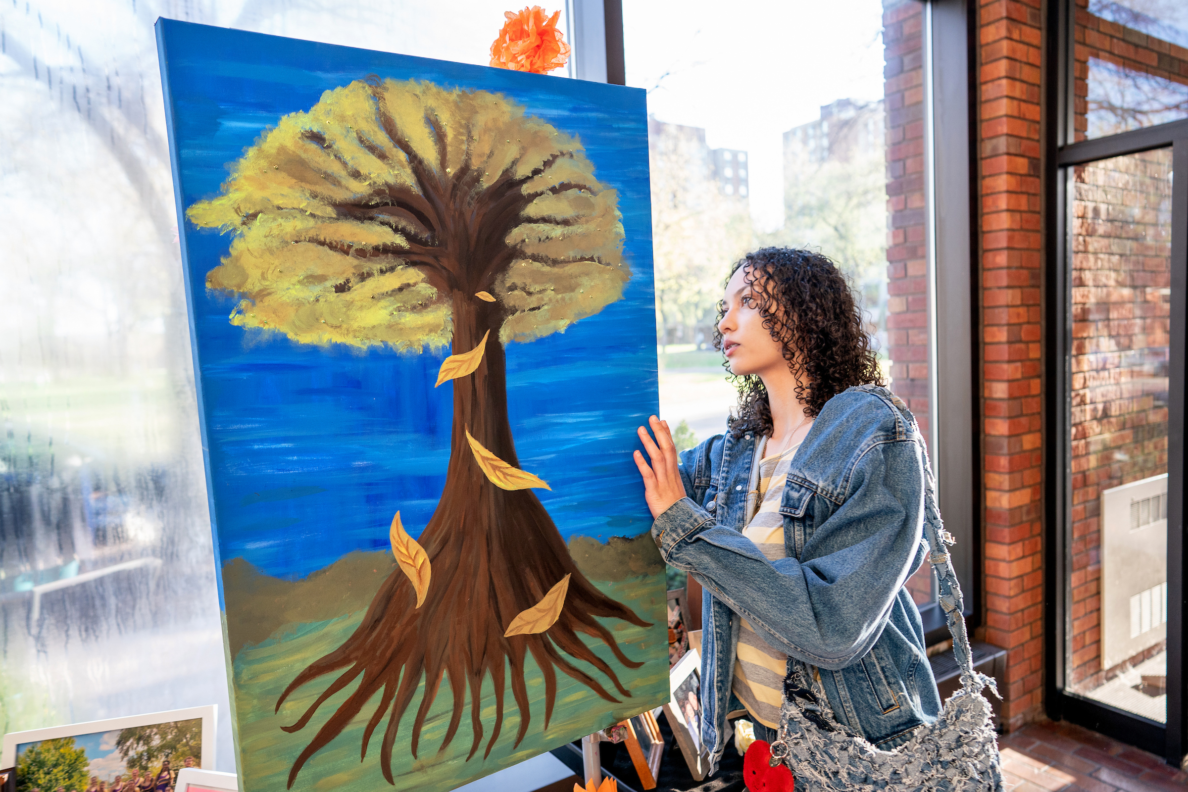 Student looking at a painting of a tree.